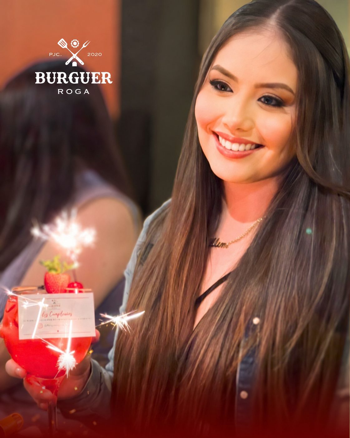 Cumpleañera sonriendo con su copa y bengalas en Burguer Roga